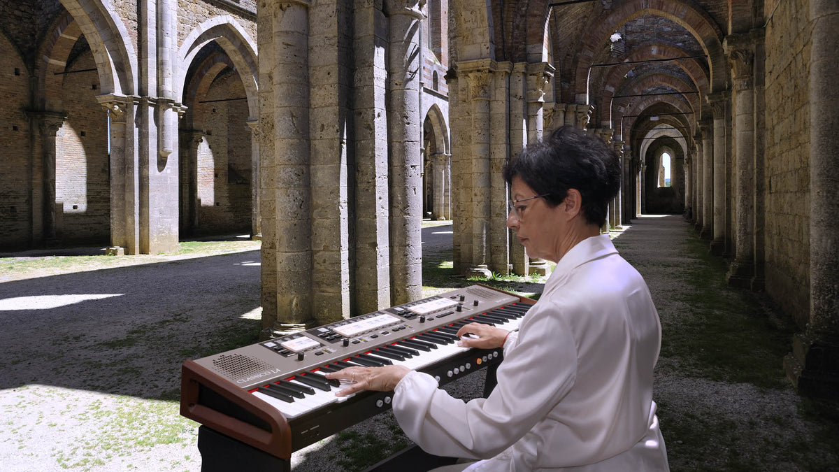 An organist playing a Dexibell CLASSICO L4 organ in the nave of an abbey