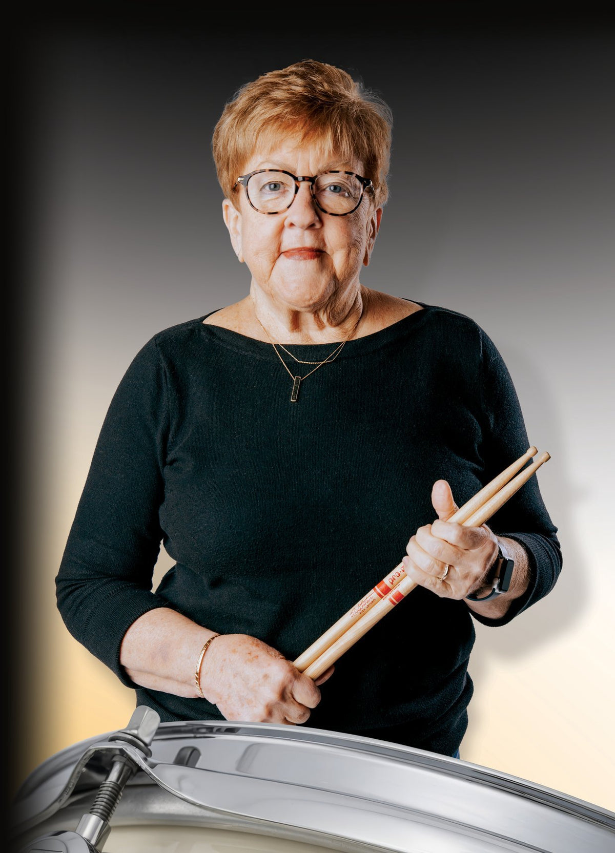 Dorothea Taylor holding drumsticks behind her ivory Signature Snare