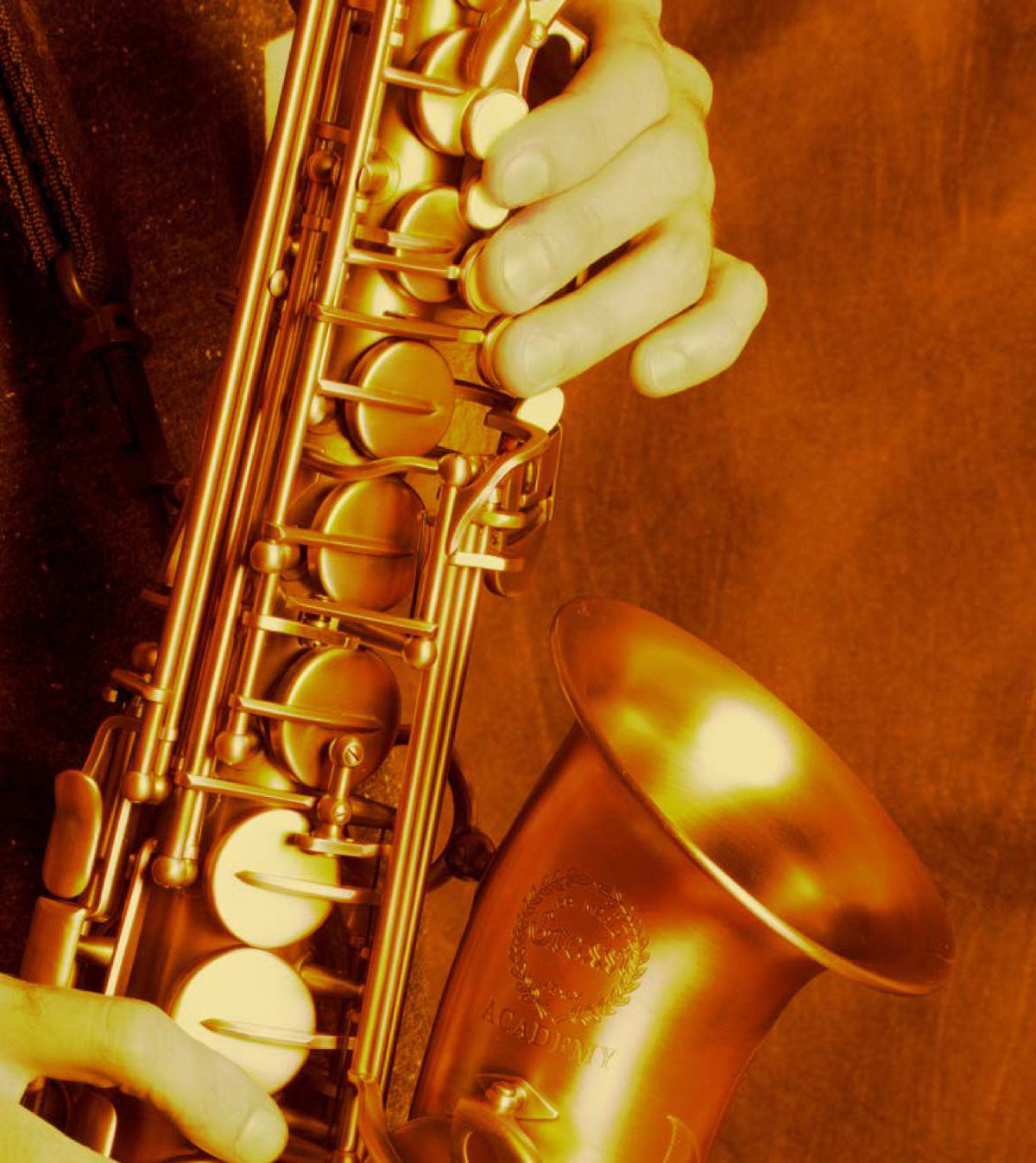 A player's hands on an Ida Maria Grassi saxophone, the Grassi crest engraved on the bell
