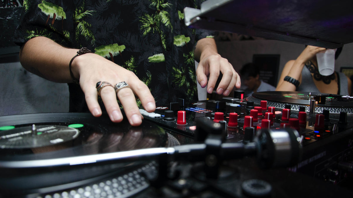 A DJ's hands on the decks and mixer during a set
